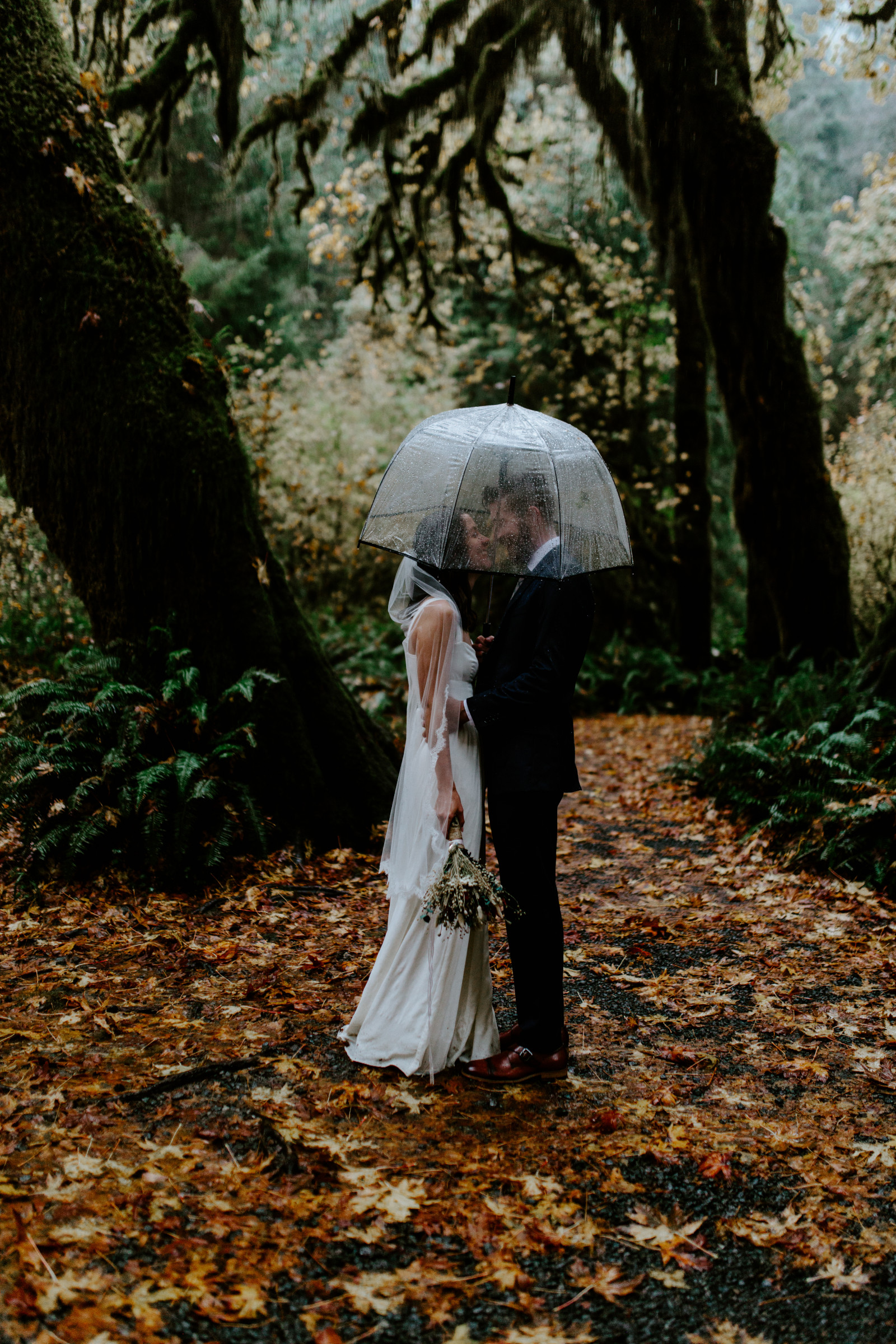 Mollie and Corey share an umbrella. Elopement photography in the Olympic National Park by Sienna Plus Josh.
