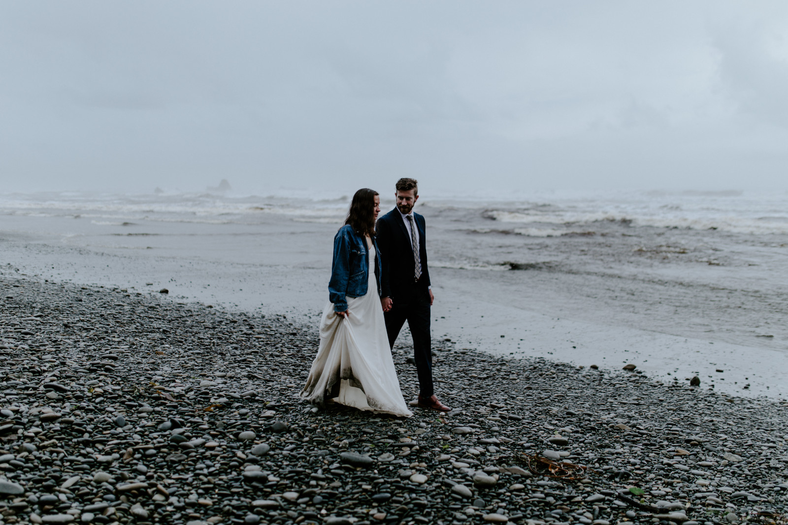 Mollie and Corey walk in the rain on the beach. Elopement photography at Olympic National Park by Sienna Plus Josh.