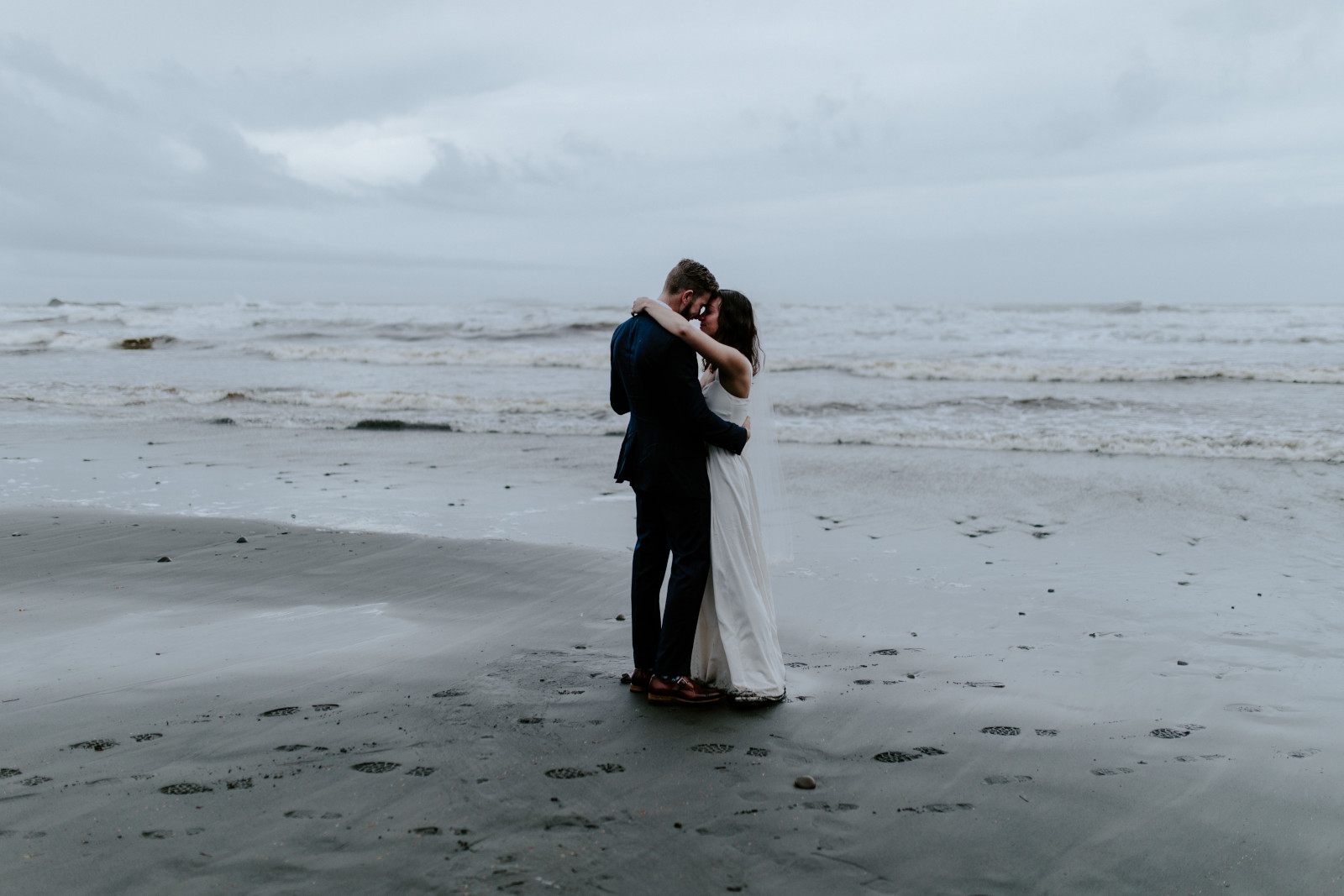 Mollie and Corey dance on the rainy beach. Elopement photography at Olympic National Park by Sienna Plus Josh.