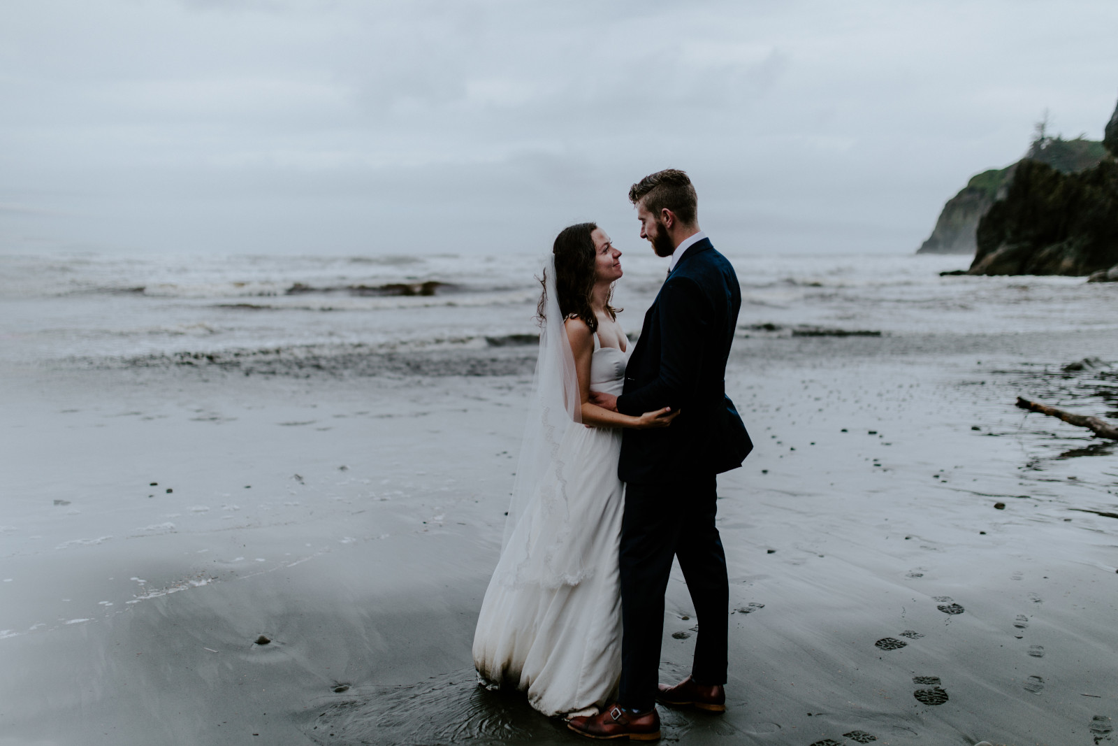 Mollie and Corey stand together on the beach. Elopement photography at Olympic National Park by Sienna Plus Josh.