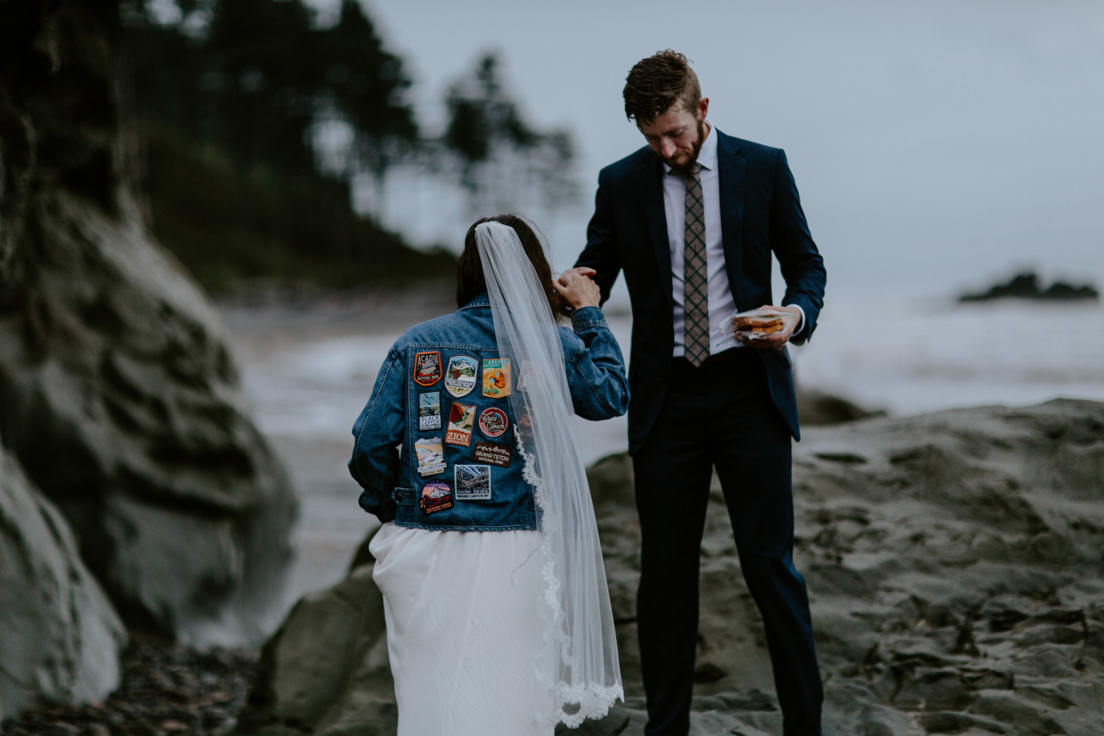 Corey helps Mollie onto the rocks. Elopement photography at Olympic National Park by Sienna Plus Josh.