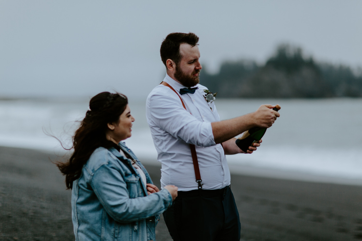 Jack and Brooke popping champagne at Rialto beach. Elopement photography at Olympic National Park by Sienna Plus Josh.