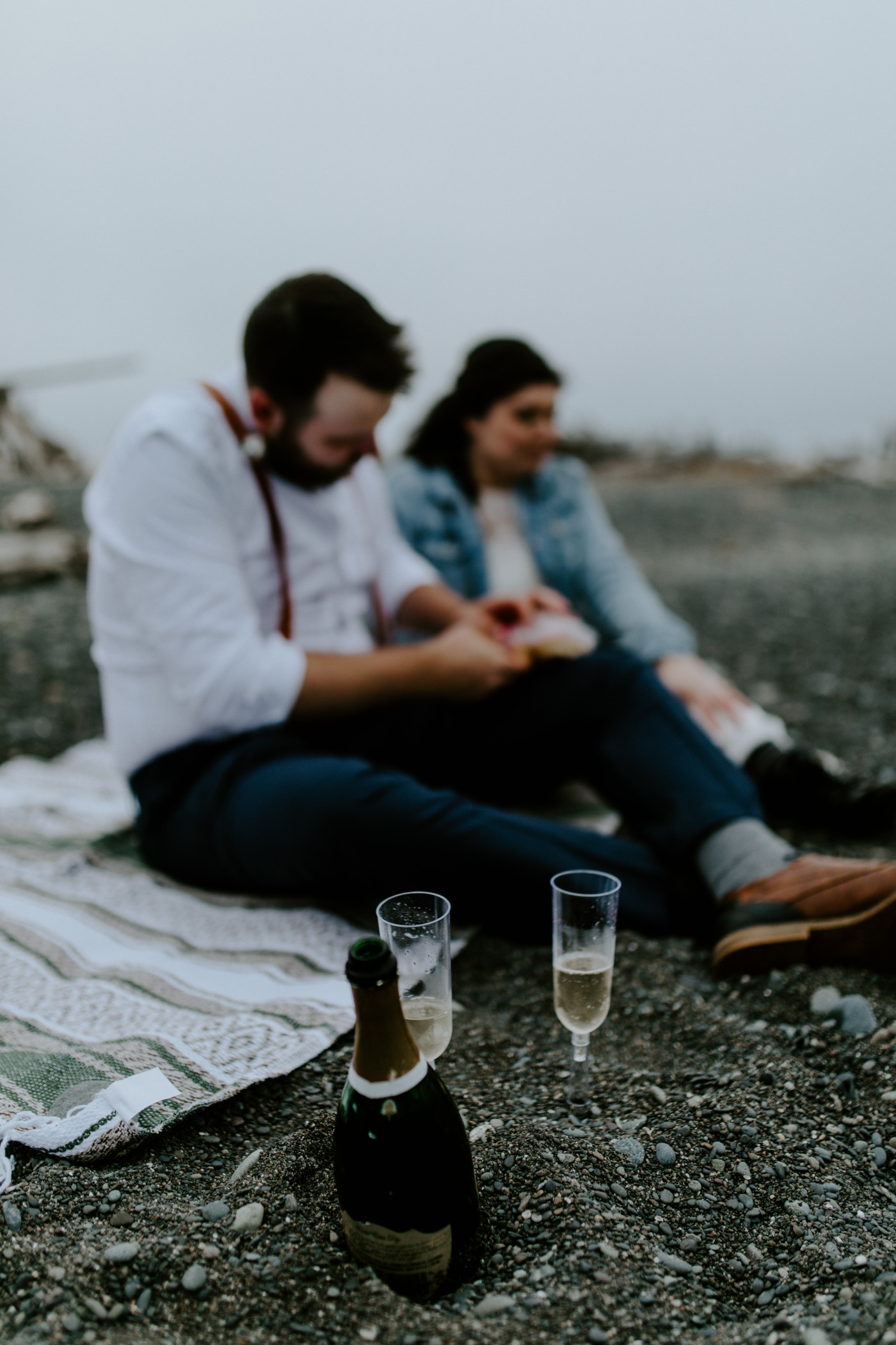 Jack and Brooke sit on Rialto beach. Elopement photography at Olympic National Park by Sienna Plus Josh.