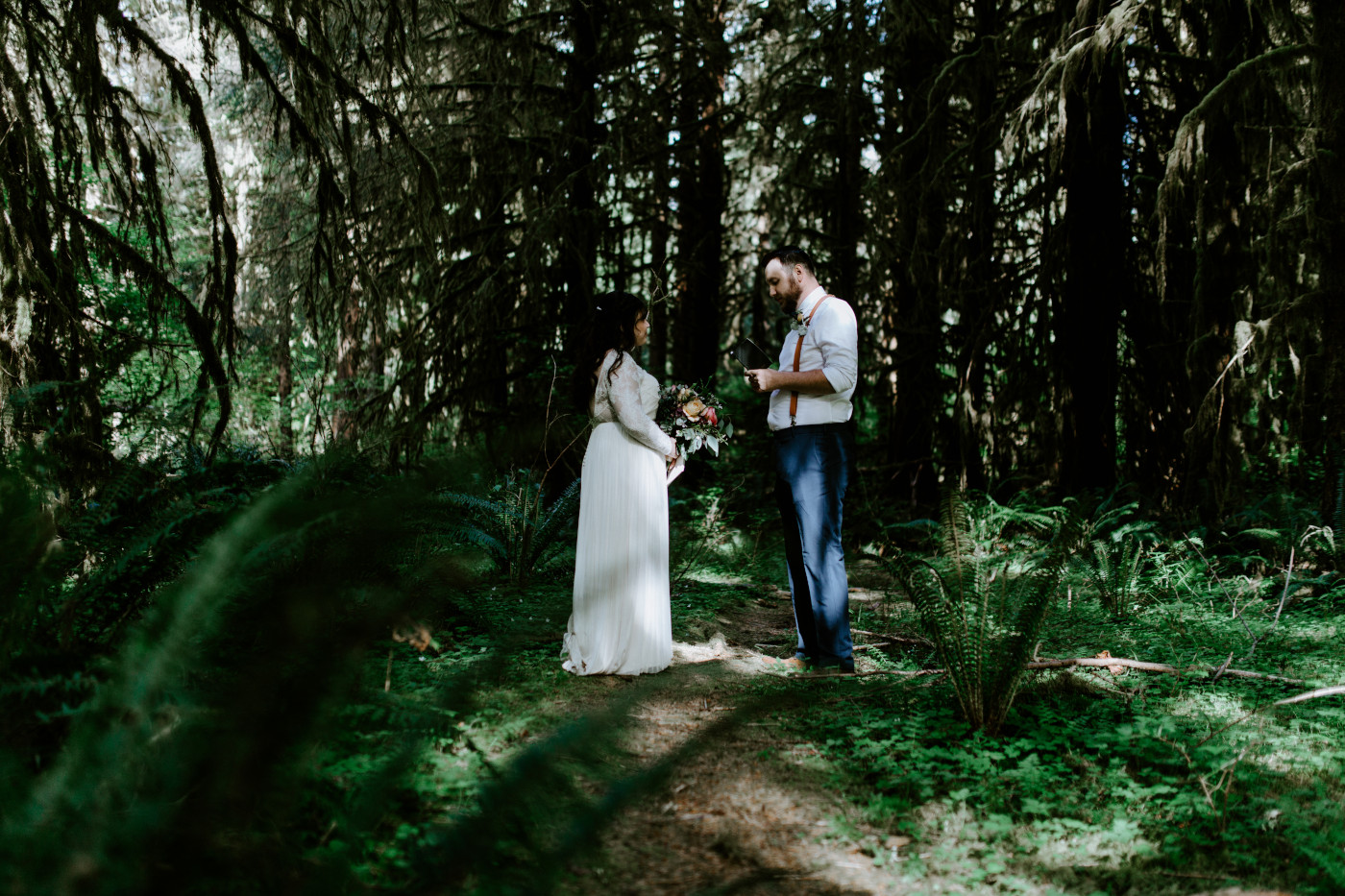 Brooke and Jack read vows to each other in the middle of the Hoh Rainforest. Elopement photography at Olympic National Park by Sienna Plus Josh.
