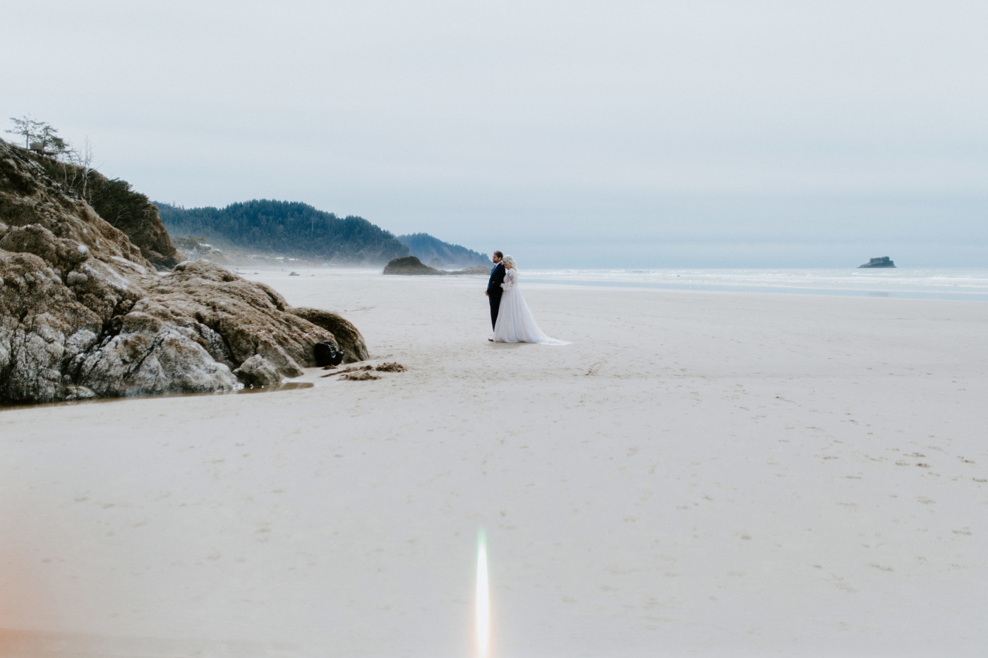 Katie hugs Ben on the sand on the beach along the Oregon coast.