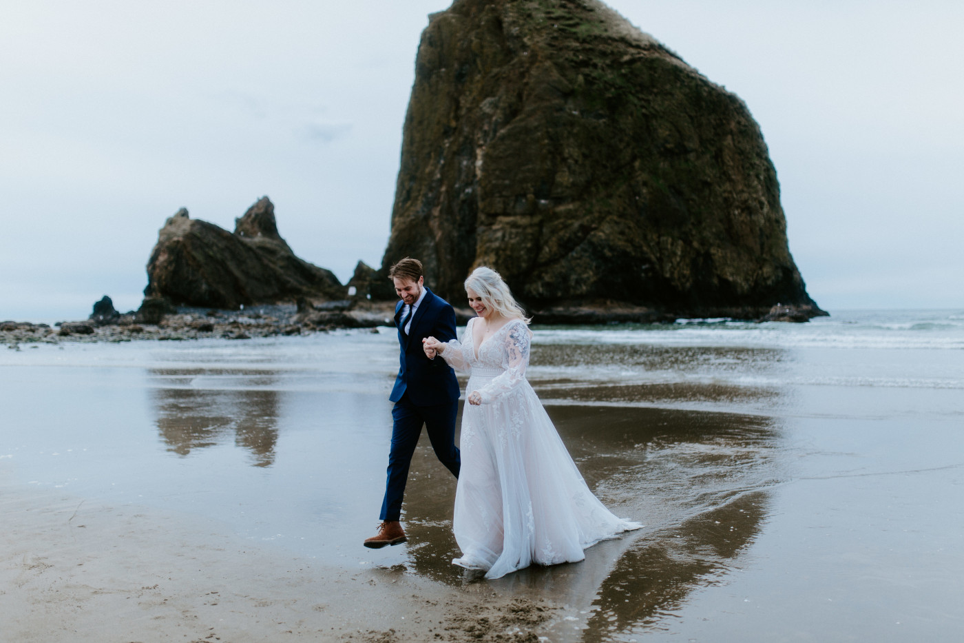 Ben and Katie walk along the sand on the Oregon coast.