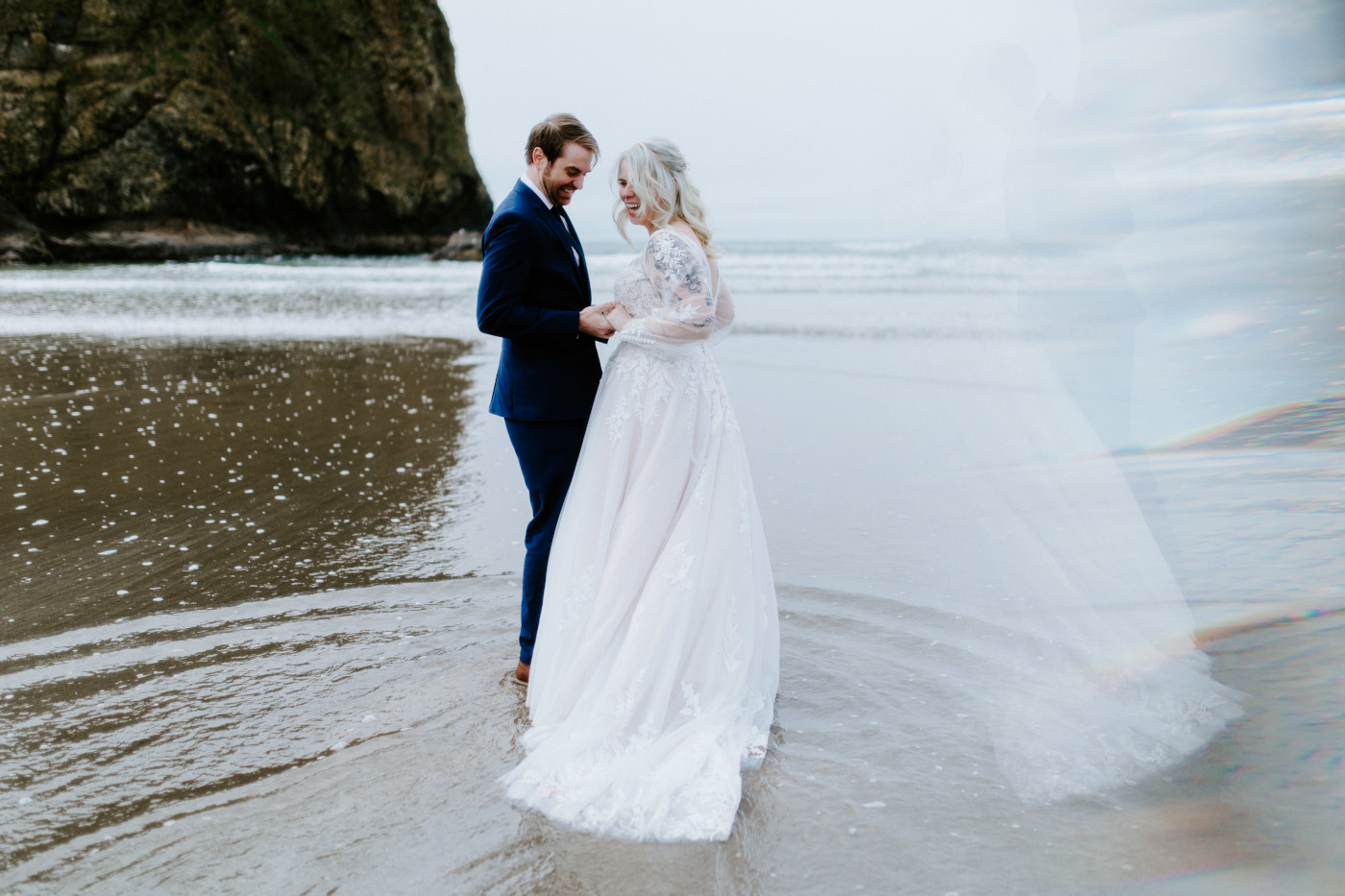 Katie and Ben walk along the sand on the Oregon coast.