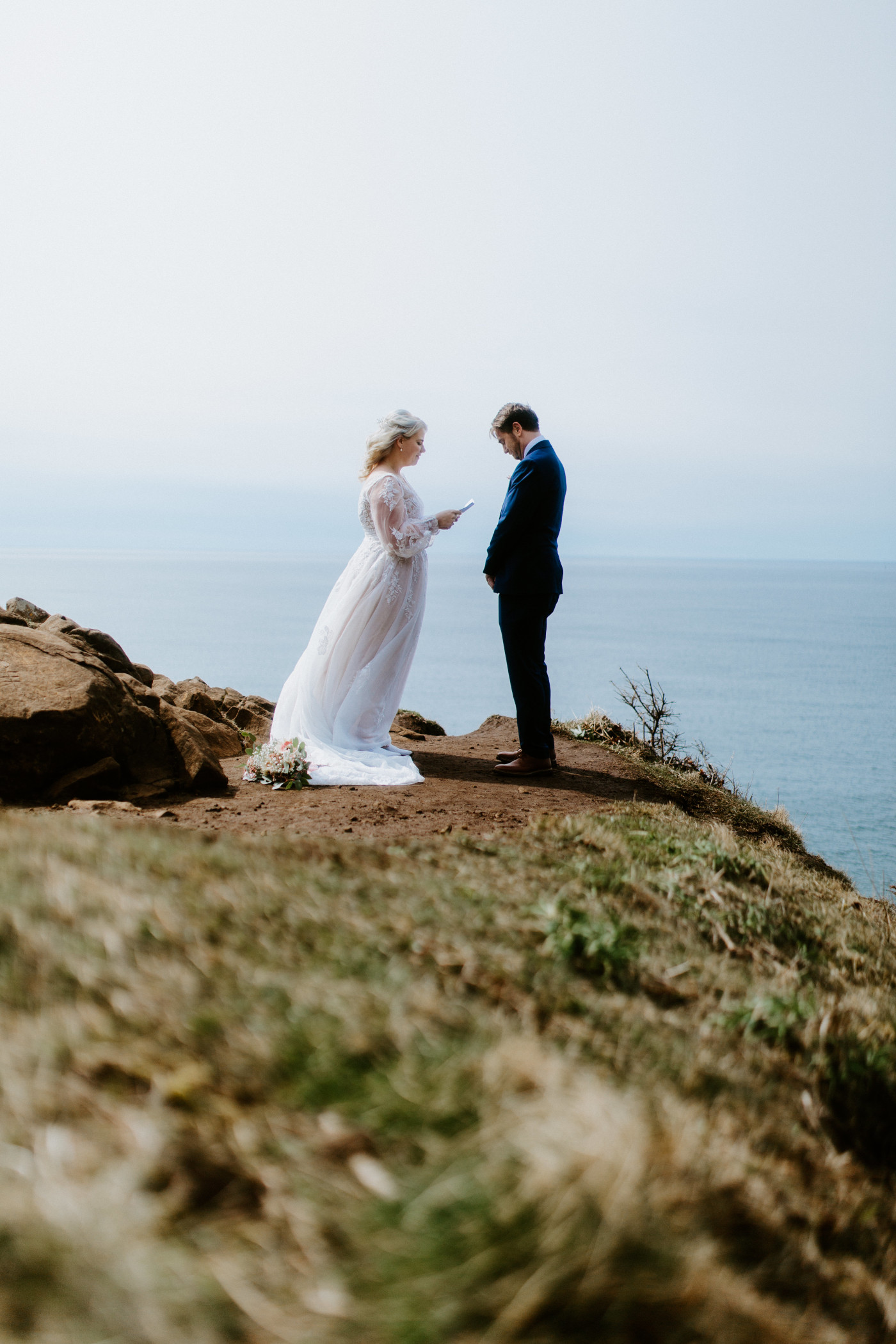 Katie recites her vows at the Oregon coast during their elopement ceremony.