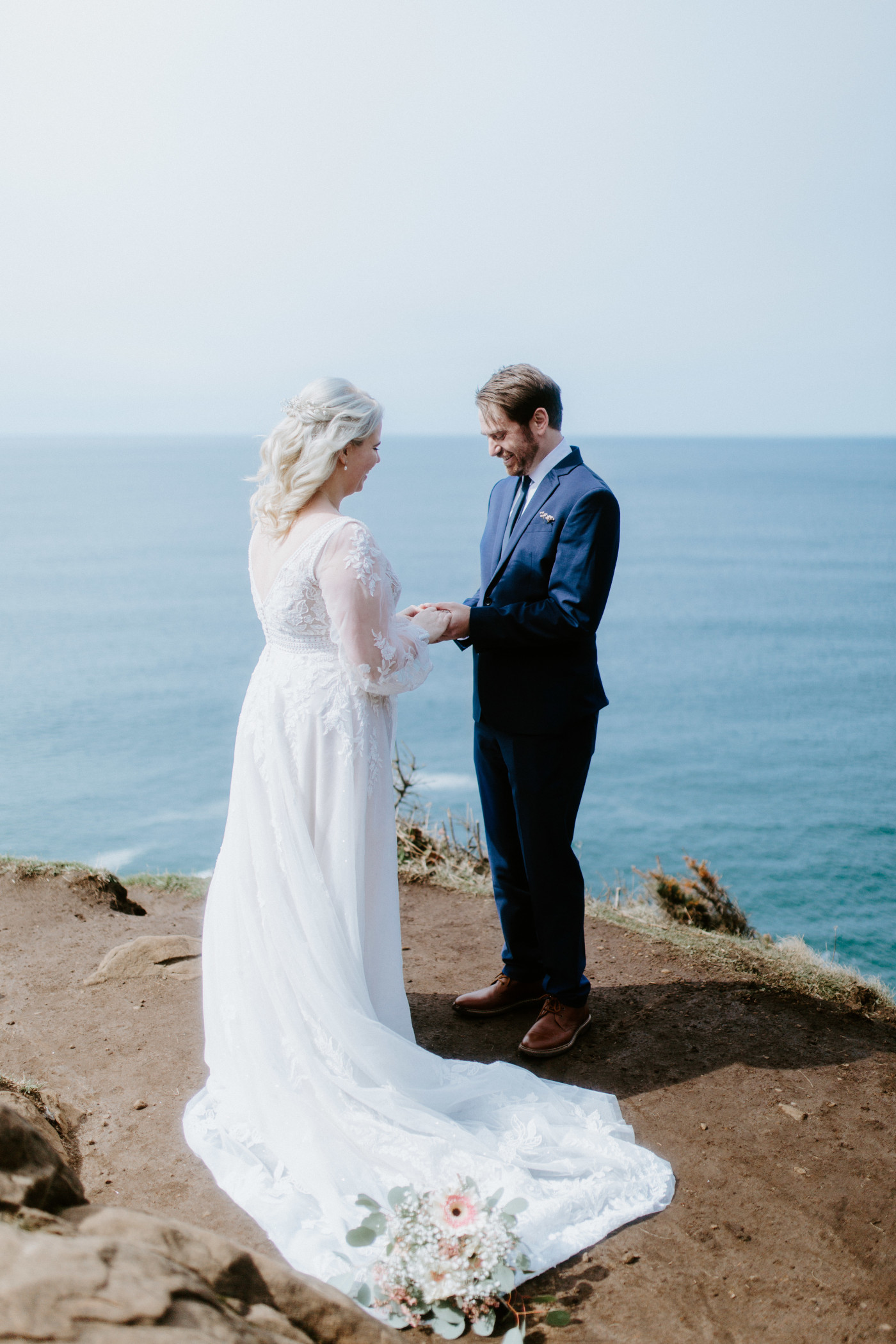 Katie and Ben stand hand in hand at the Oregon coast during their elopement ceremony.