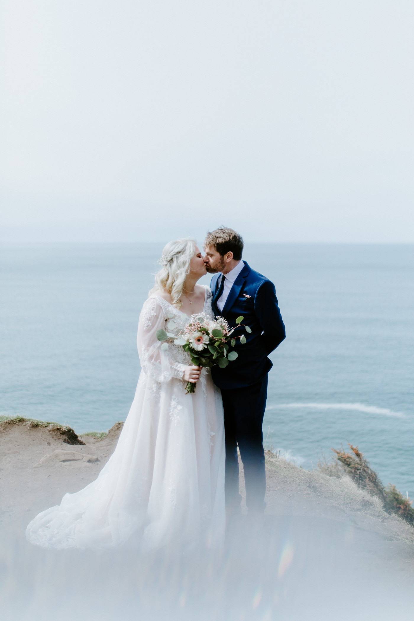 Katie and Ben smile at each other at the Oregon coast during their elopement ceremony.