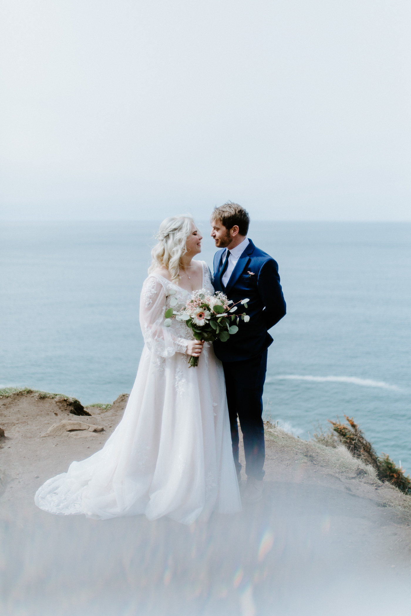 Katie and Ben stand together at the Oregon coast during their elopement ceremony.