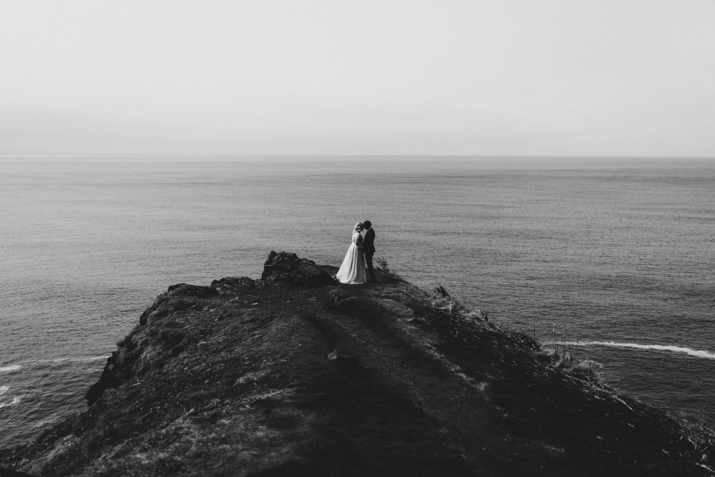 Ben and Katie stand at the Oregon coast during their elopement ceremony.