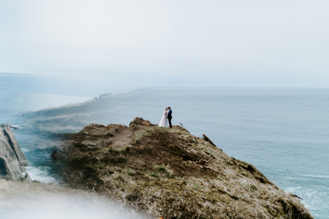 Ben and Katie stand at the Oregon coast during their elopement ceremony.