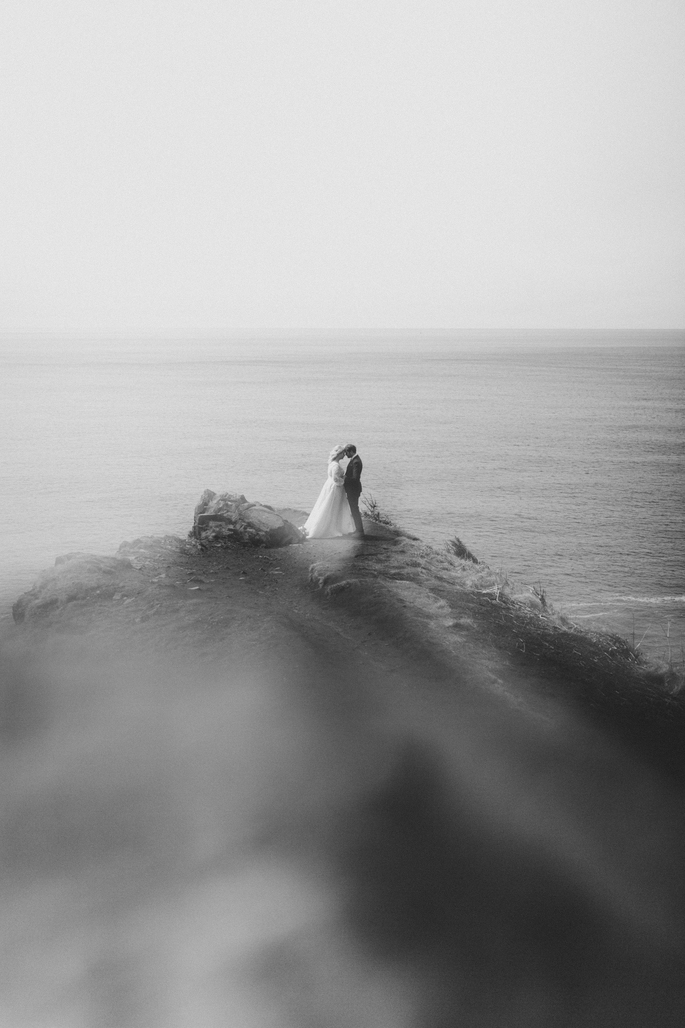 Ben and Katie stand at the Oregon cliff line during their elopement ceremony.