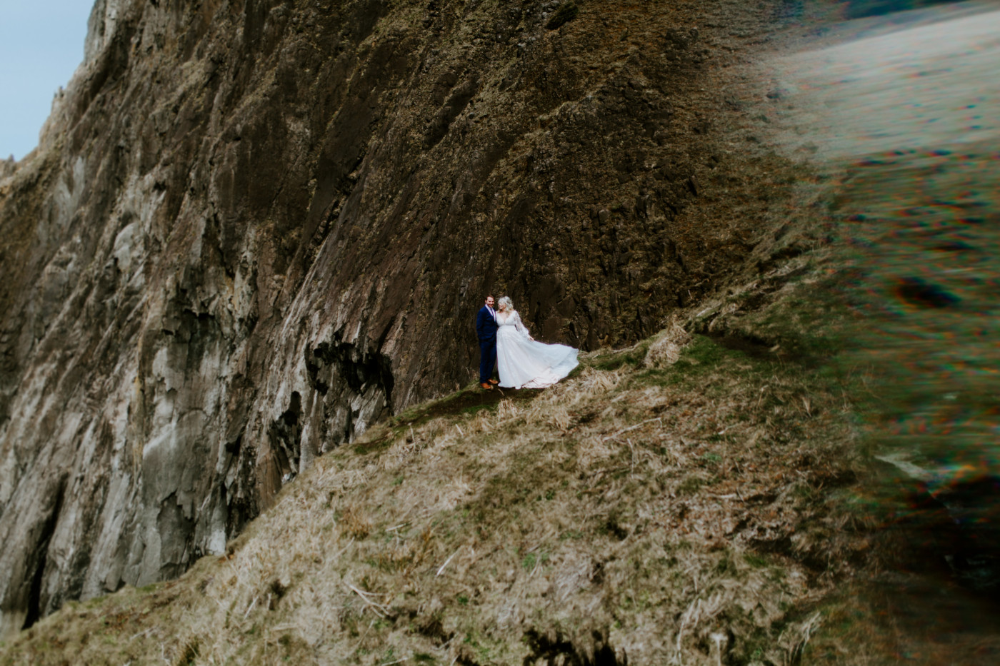 Katie and Ben stand at the Oregon cliff line during their elopement ceremony.