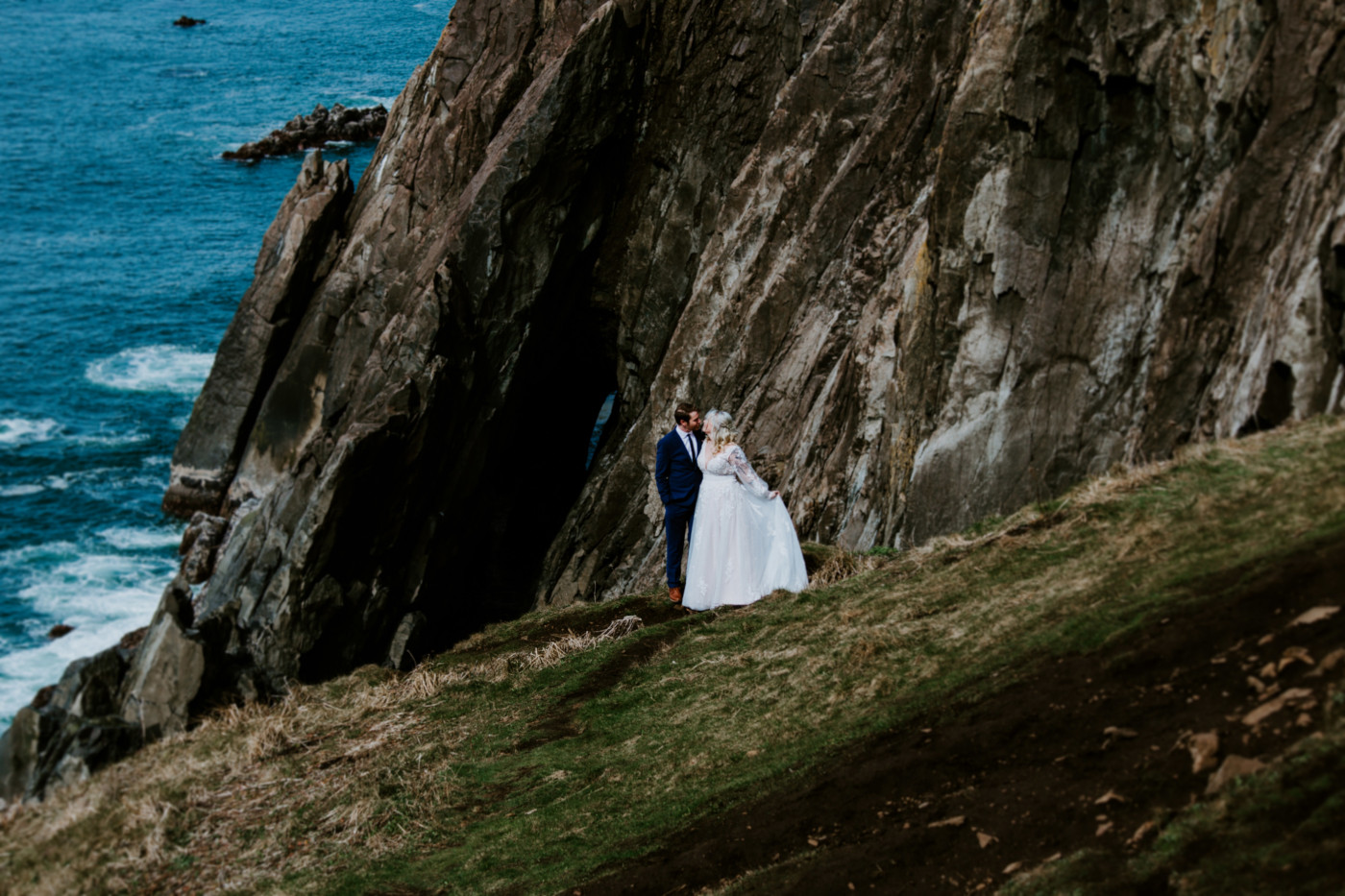 Ben and Katie go in for a kiss at the Oregon cliff line after their elopement ceremony.