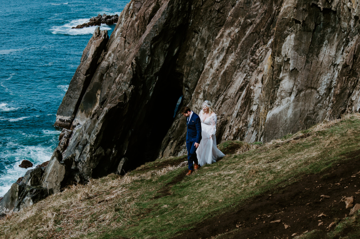 Ben and Katie walk along the Oregon cliff line after their elopement ceremony.