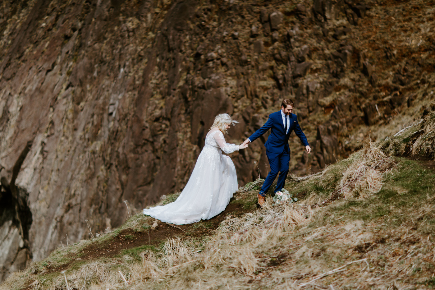 Katie and Ben walk along the Oregon cliff line after their elopement ceremony.