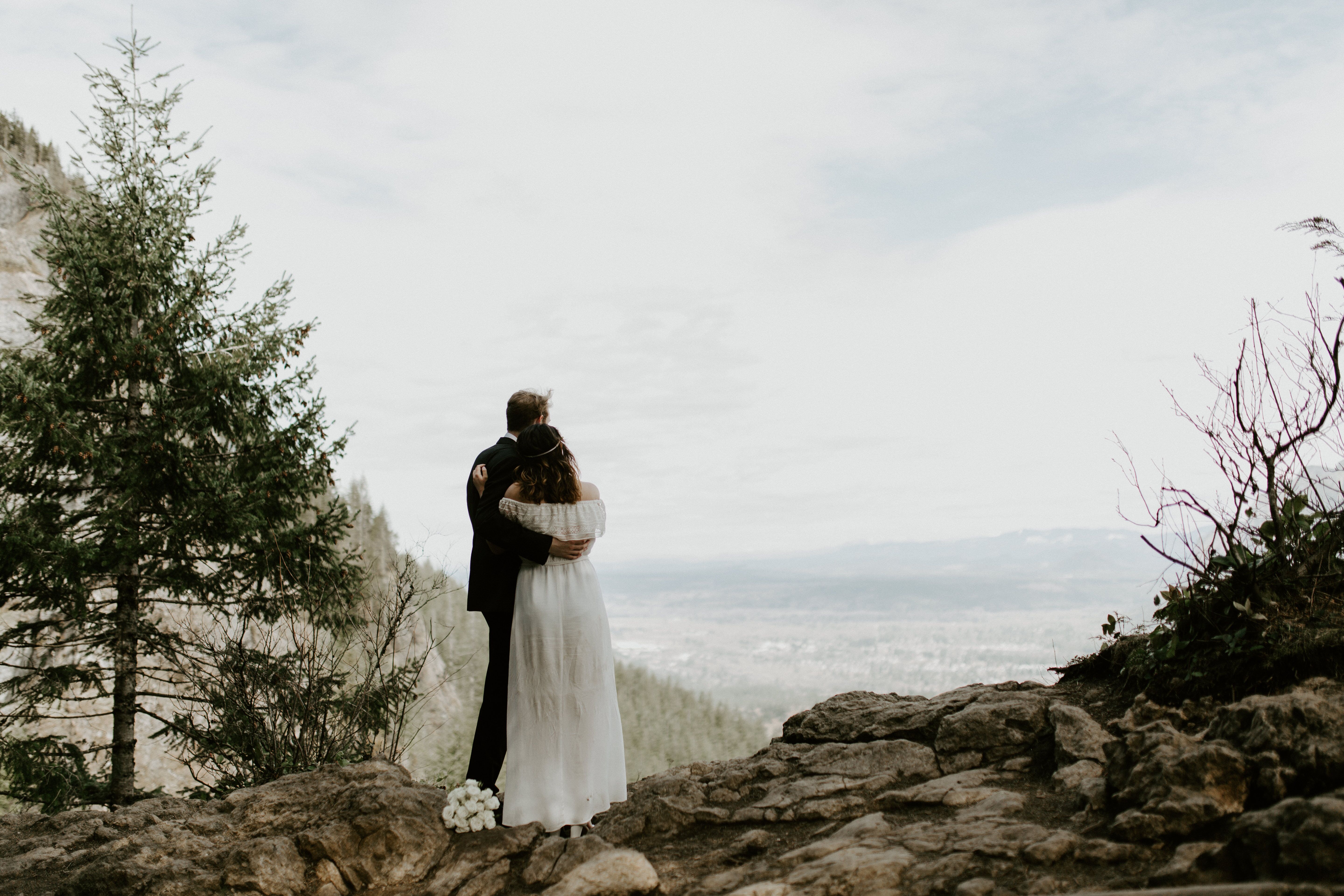 Michael and Winnifred look out on the view of Washington state from the cliff of Rattlesnake Ledge. Elopement adventure shoot at Rattlesnake Ledge, Washington.