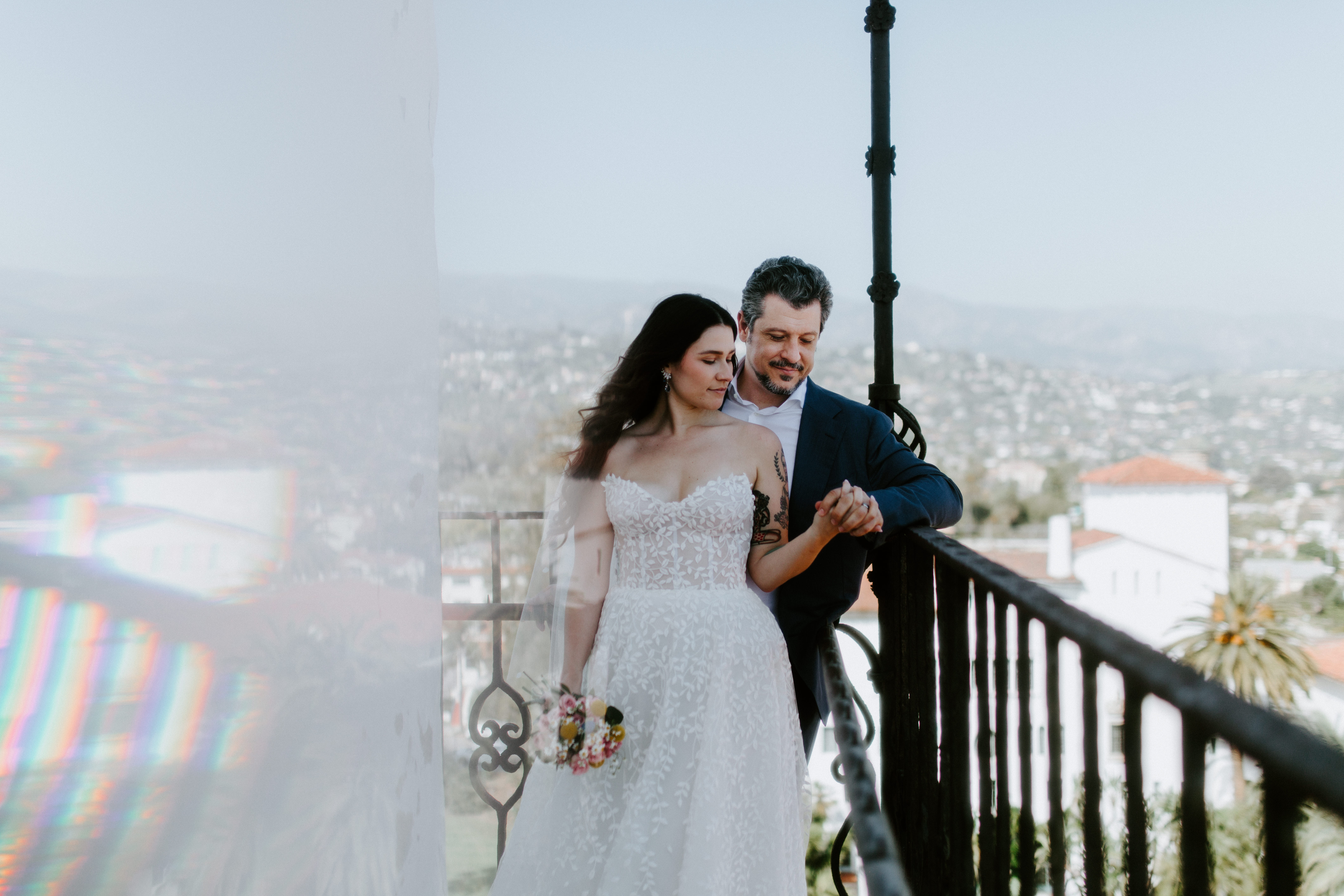 Newlyweds stand together at the top of the Santa Barbara courthouse in Santa Barbara, California.