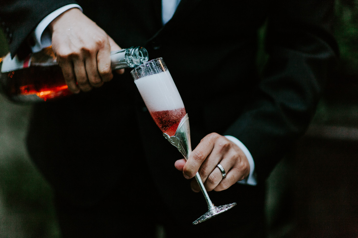 Sam pours a bottle of champagne at Skamania House, Washington. Elopement photography in Portland Oregon by Sienna Plus Josh.