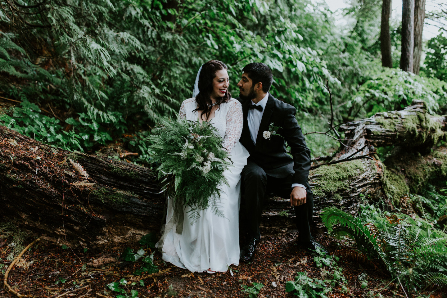 Sam and Sarah sit next to each other on a log at the Columbia River Gorge in Oregon for her Oregon Adventure. Elopement photography in Portland Oregon by Sienna Plus Josh.