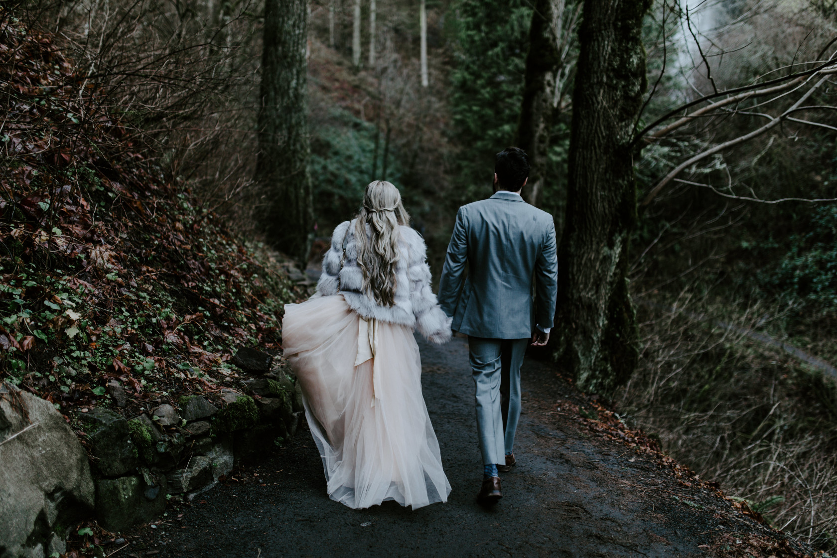 Tyanna and Boris hold hands while walking a trail in Latourell Falls, OR. Adventure elopement in the Columbia River Gorge by Sienna Plus Josh.