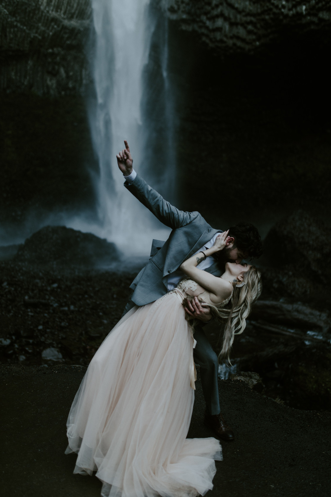 Boris dips Tyanna while kissing at Latourell Falls, OR. Adventure elopement in the Columbia River Gorge by Sienna Plus Josh.