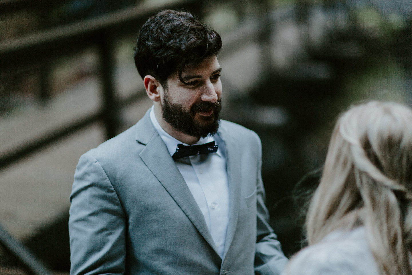 Boris admires Tyanna during their elopement ceremony in Latourell Falls, OR. Adventure elopement in the Columbia River Gorge by Sienna Plus Josh.