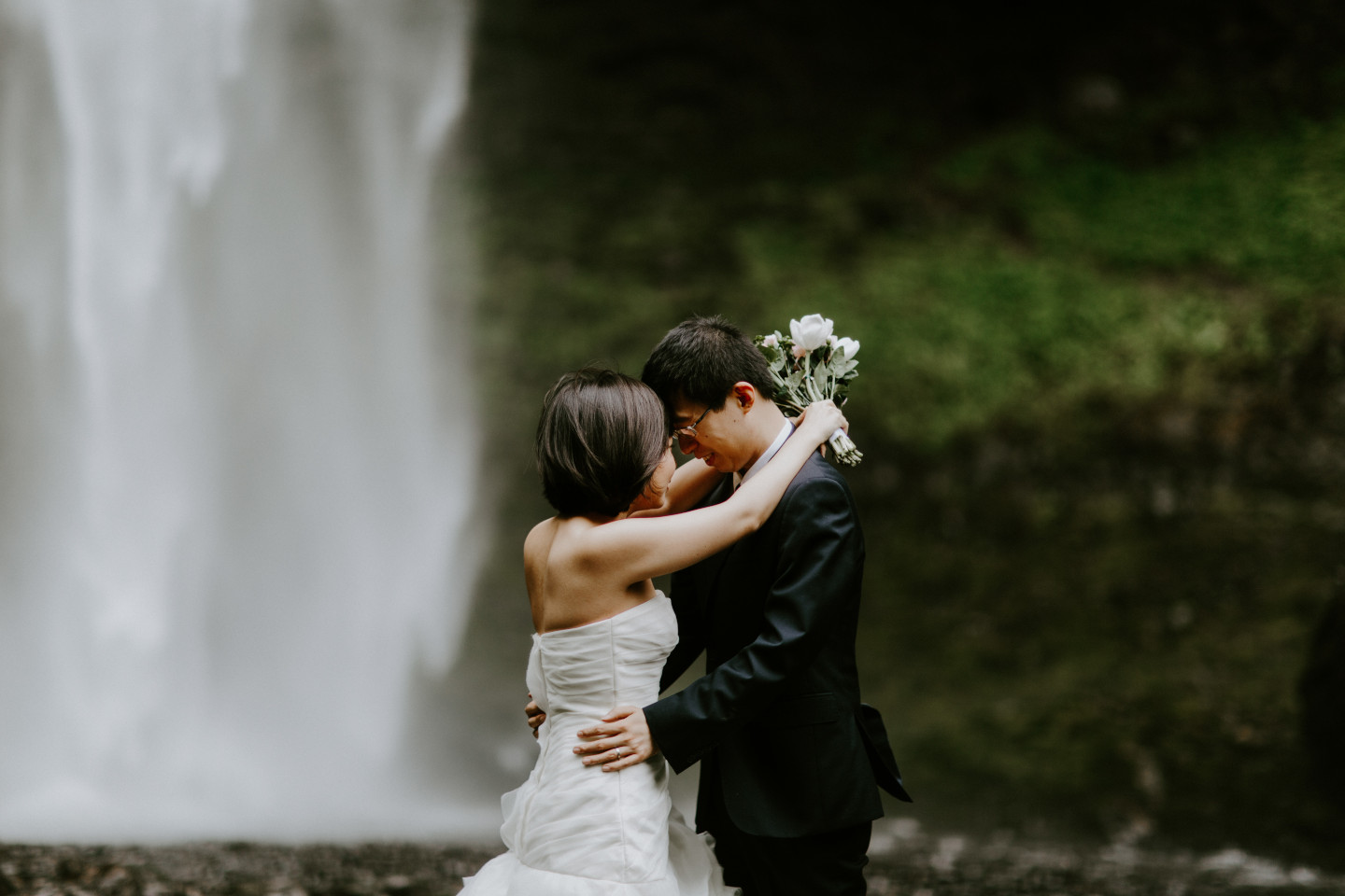 Alex and Valerie stand in front of a waterfall. Elopement wedding photography at Mount Hood by Sienna Plus Josh.
