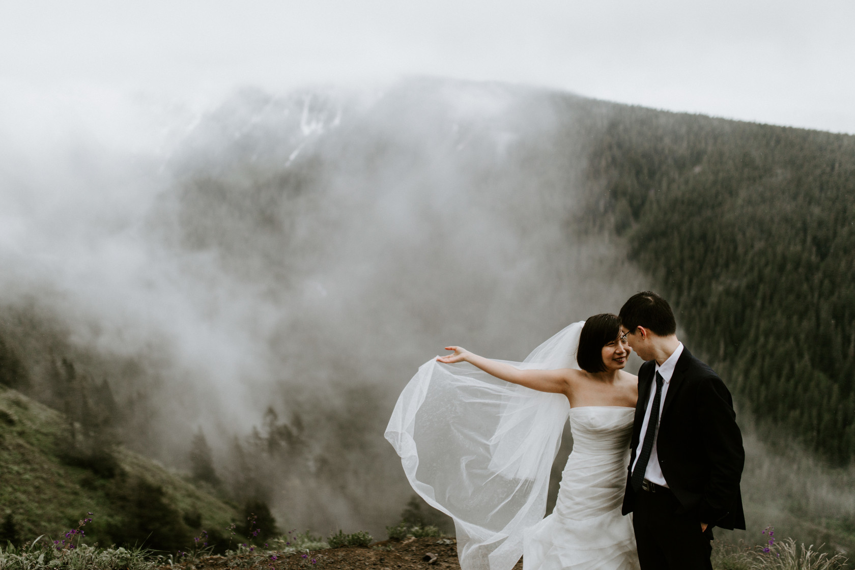 Valerie holds her veil as Alex goes in for a kiss. Elopement wedding photography at Mount Hood by Sienna Plus Josh.