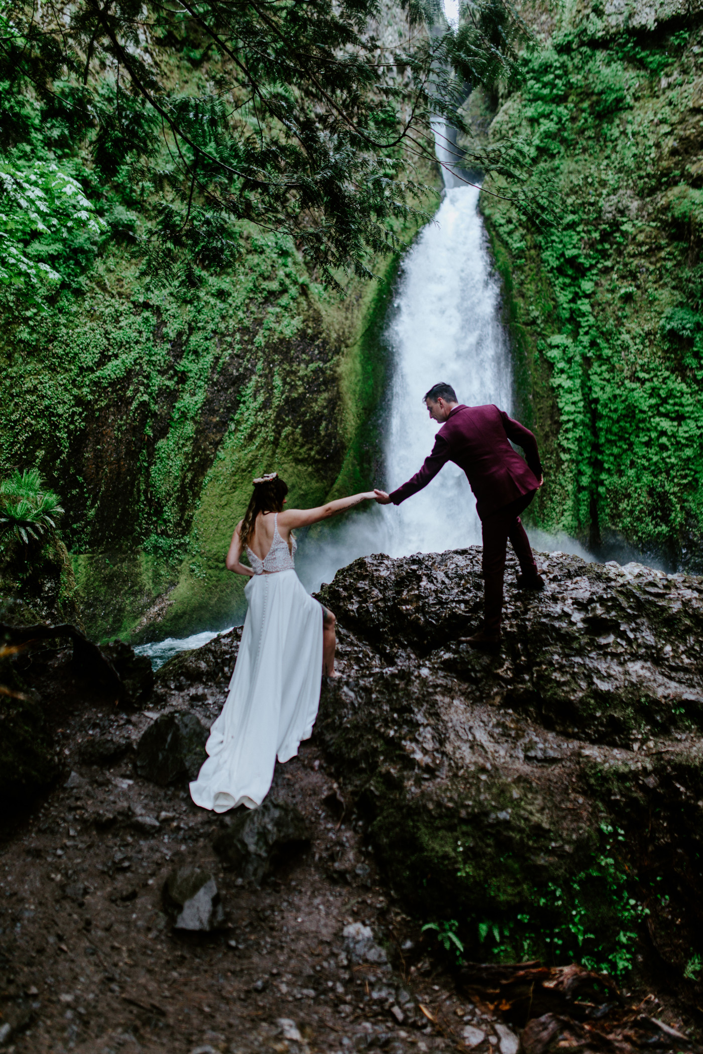 Andrew helps his new bride up on the rock at Wahcella Falls where they had their elopement ceremony.