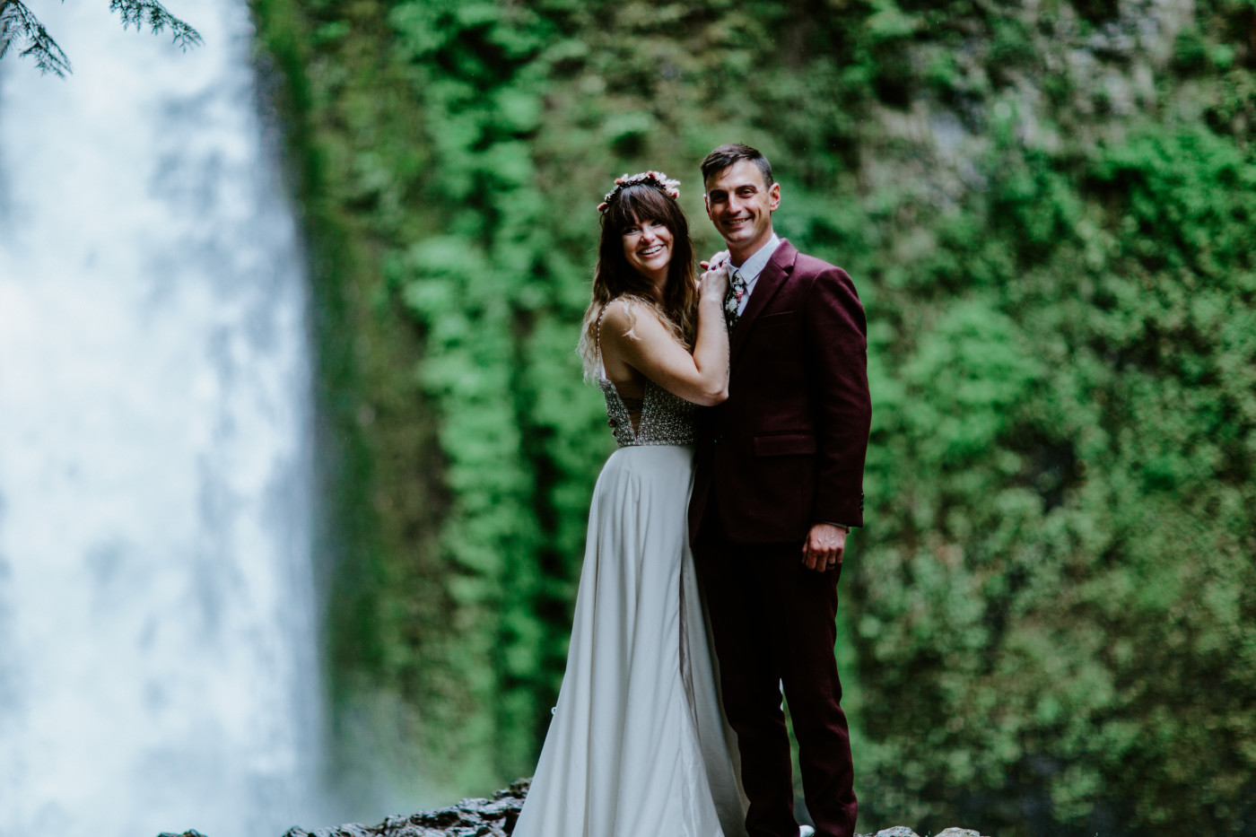 Jordan rests her hands on Andrew's shoulders in front of Wahcella Falls.