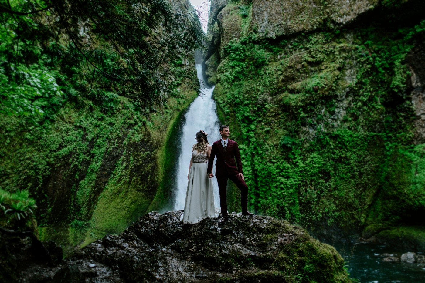 Andrew and Jordan stand in front of Wahcella Falls where they had their elopement.