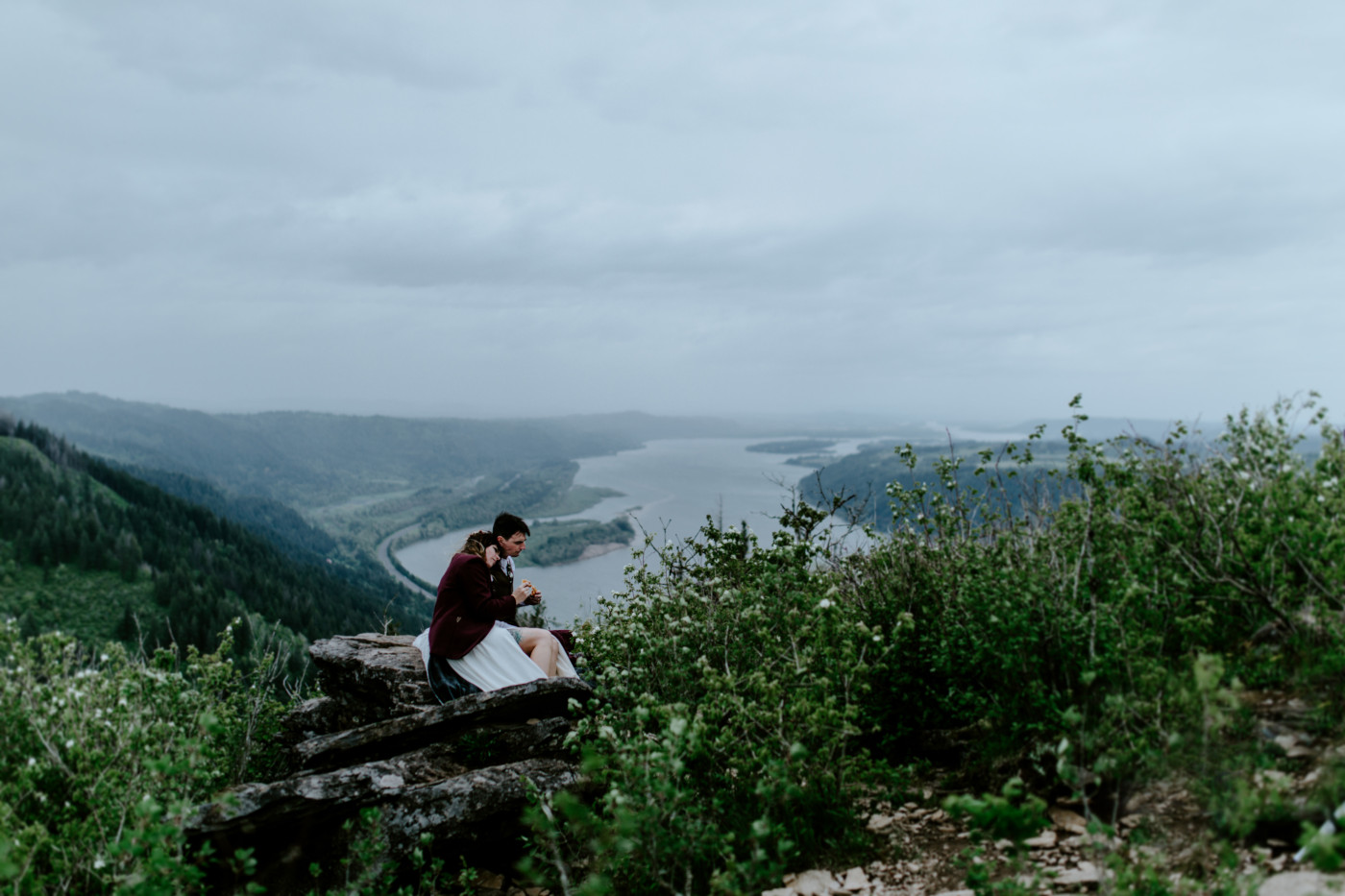 The Columbia River behind Jordan and Andrew as they sit on top of Angels Rest.