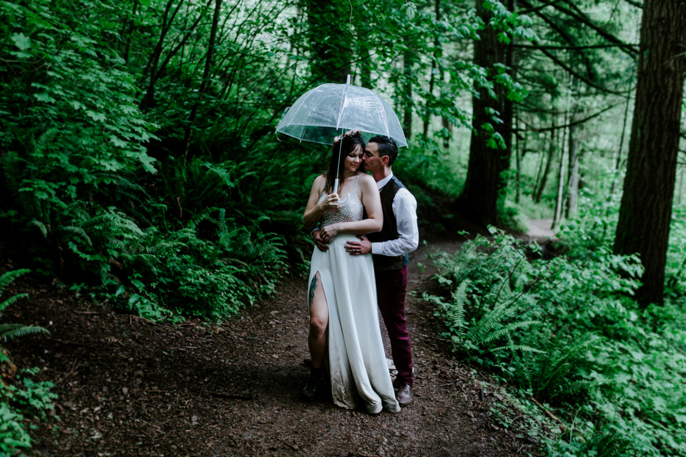 Andrew and Jordan stand under an umbrella on a trail in the Columbia River Gorge.